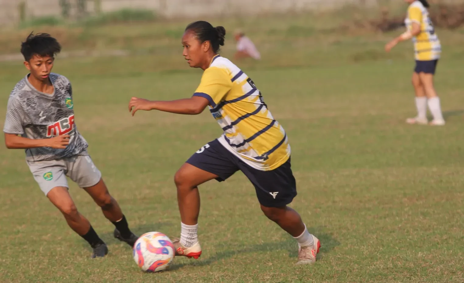 Bek Persida Putri Ellen mencoba melewati pemain PON Kaltim Putri dalam uji coba di Lapangan Semambung, Sidoarjo.